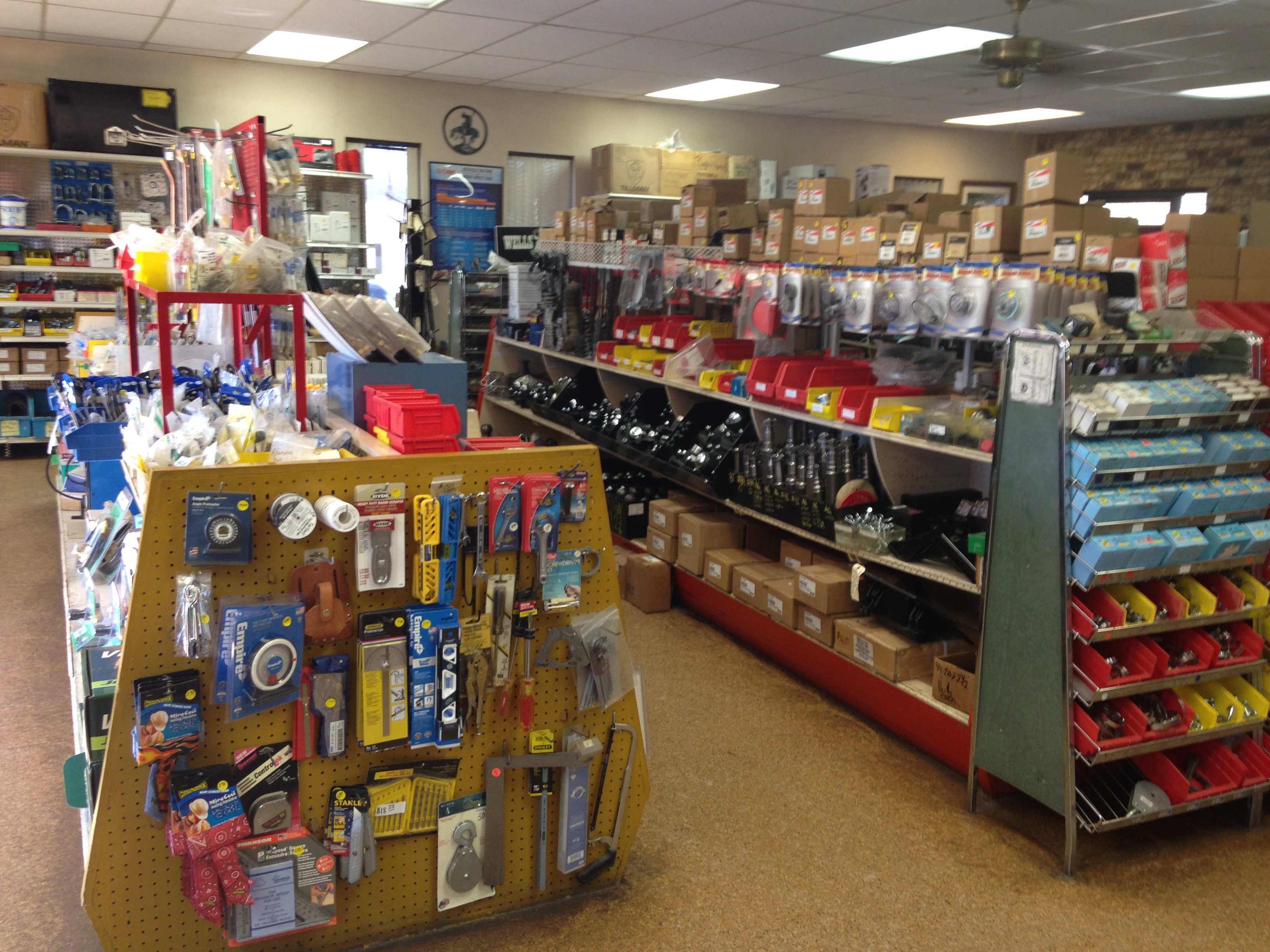 Well-stocked supply counter inside Riggs Machine & Welding in Stephenville, TX, showing hardware, fittings, and trailer parts on shelves