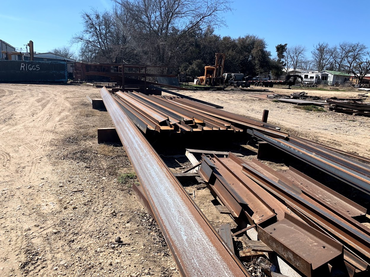 Indoor storage rack filled with round bar, flat bar, and tubing stock at Riggs Machine & Welding supply in Stephenville, TX