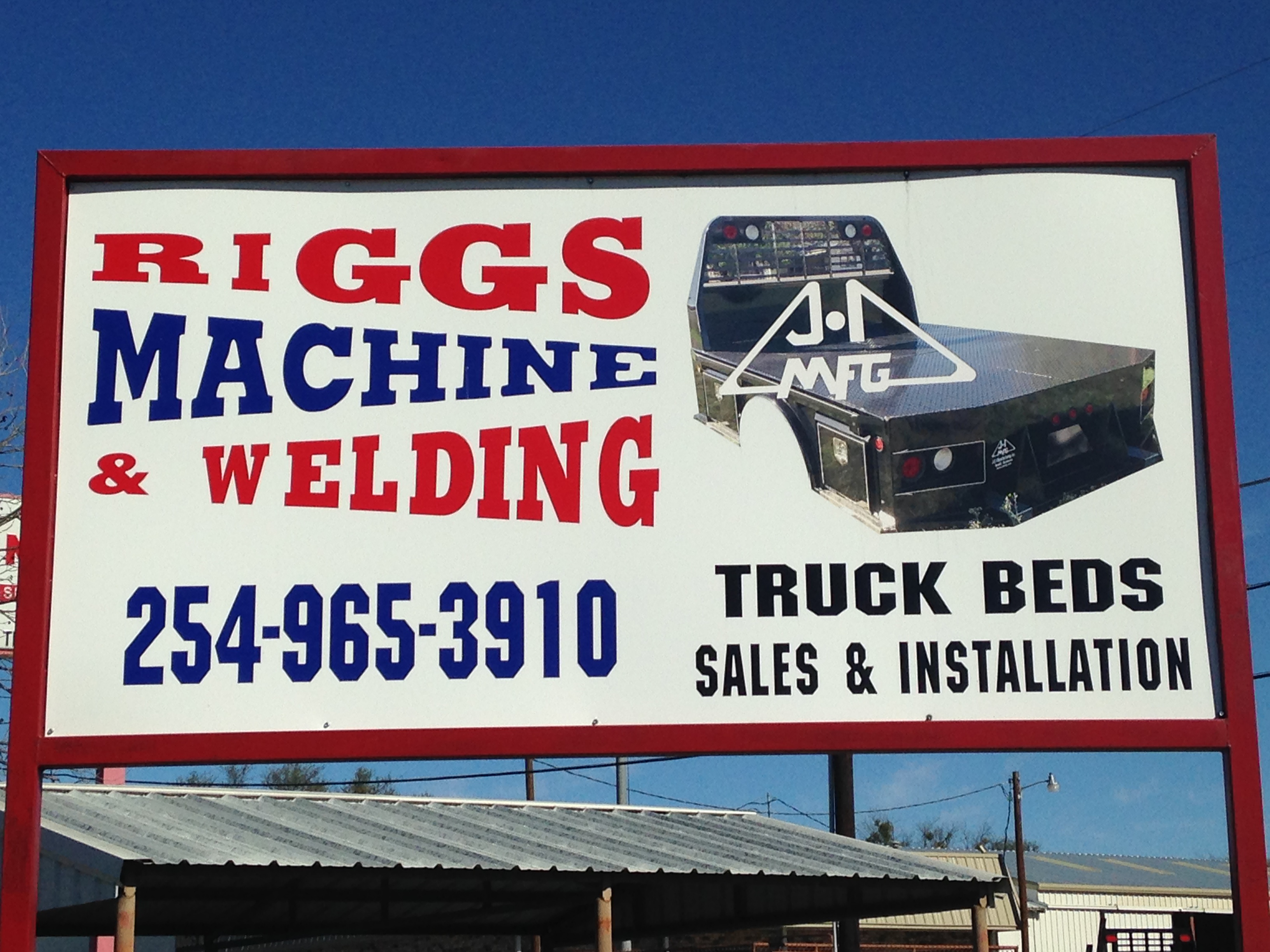 Riggs Machine & Welding roadside billboard in Stephenville, TX — showing J-I MFG truck bed photo and phone number 254-965-3910 for truck beds sales and installation