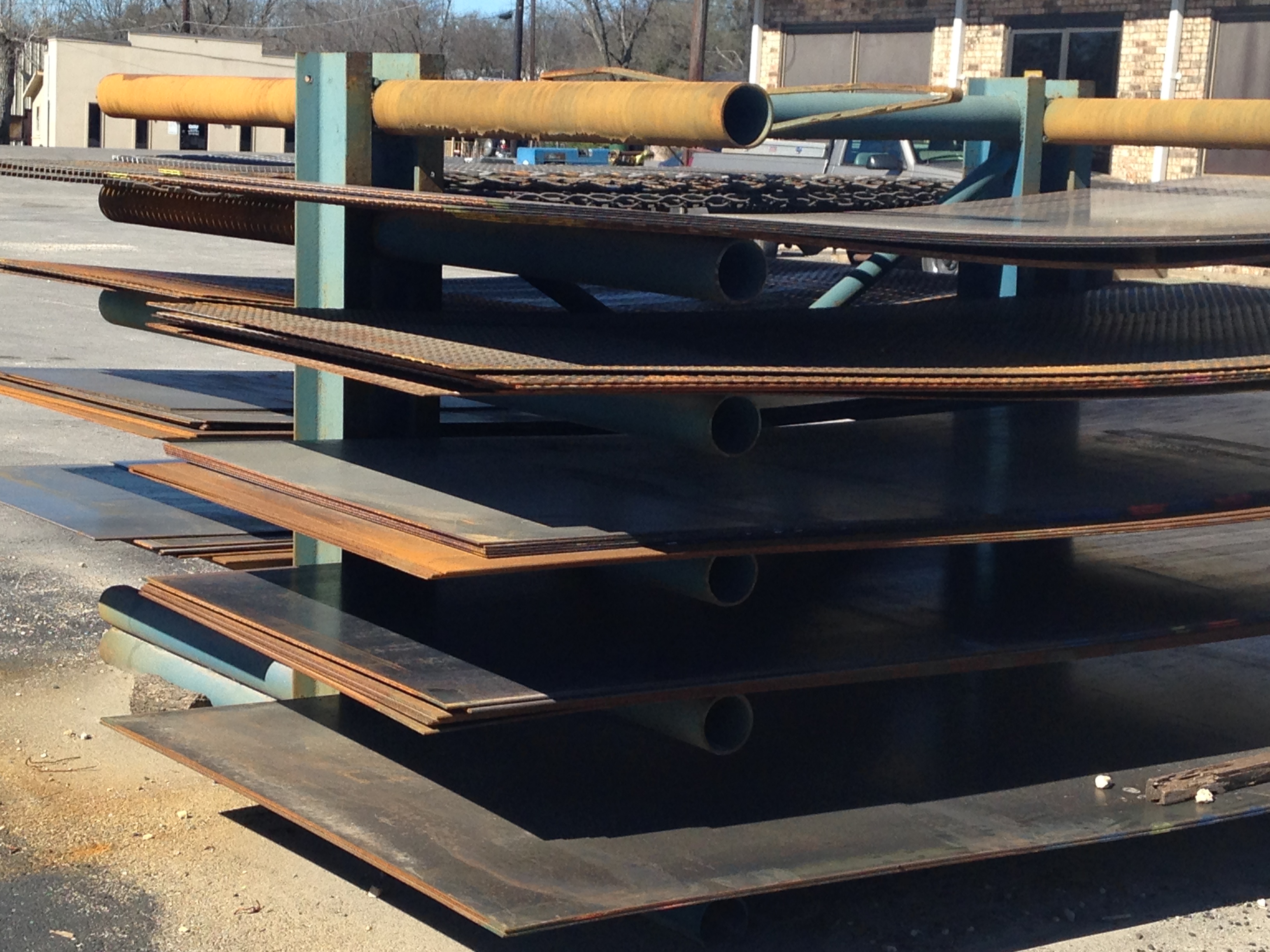 Plate steel rack with checker plate and flat sheets at Riggs Machine & Welding supply yard, Stephenville, TX