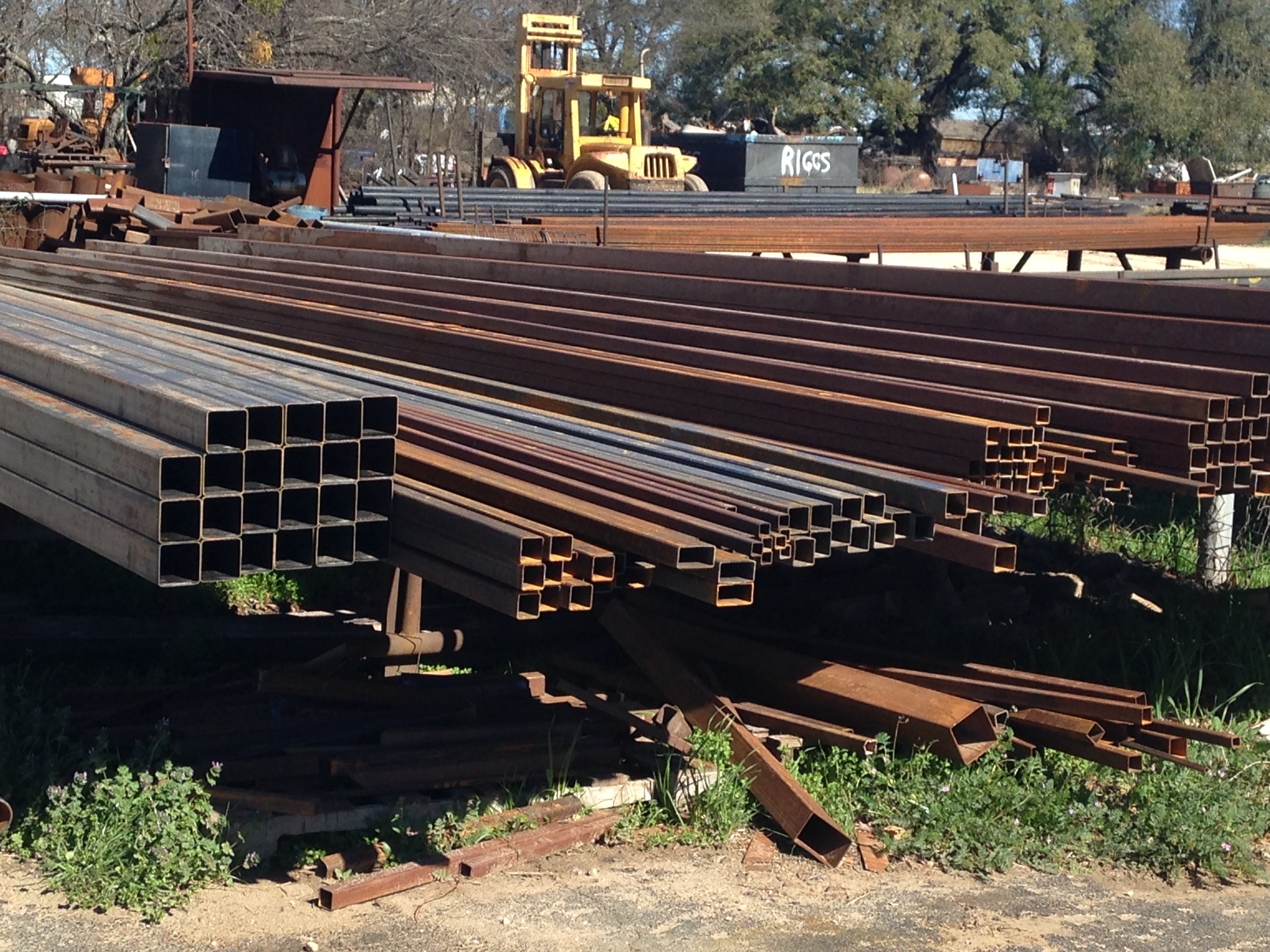 Square and rectangular hollow structural steel tubing in multiple sizes on outdoor rack at Riggs Machine & Welding, Stephenville, TX