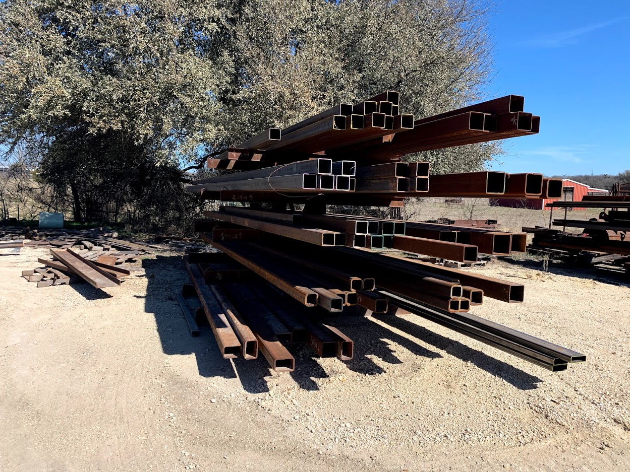 Dense racks of square structural tubing at Riggs Machine & Welding, Stephenville, TX — Riggs forklift visible in background