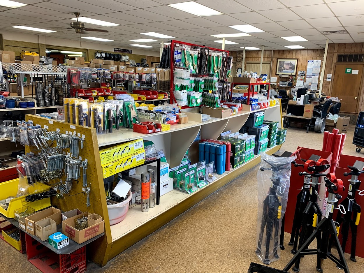 Riggs Machine & Welding supply aisle in Stephenville, TX with gas cylinder carts, Irwin Vise-Grips, torch parts, and PTO shaft rack