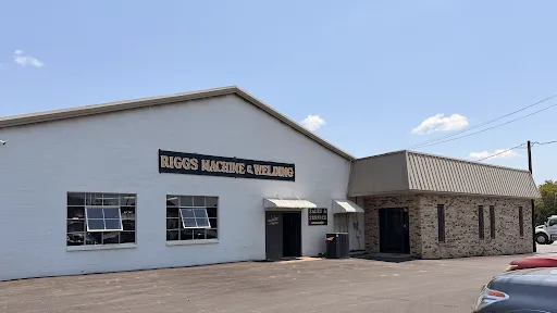 Exterior of Riggs Machine & Welding shop in Stephenville, TX — white brick building with company sign on S HWY 281, serving Erath County since 1978
